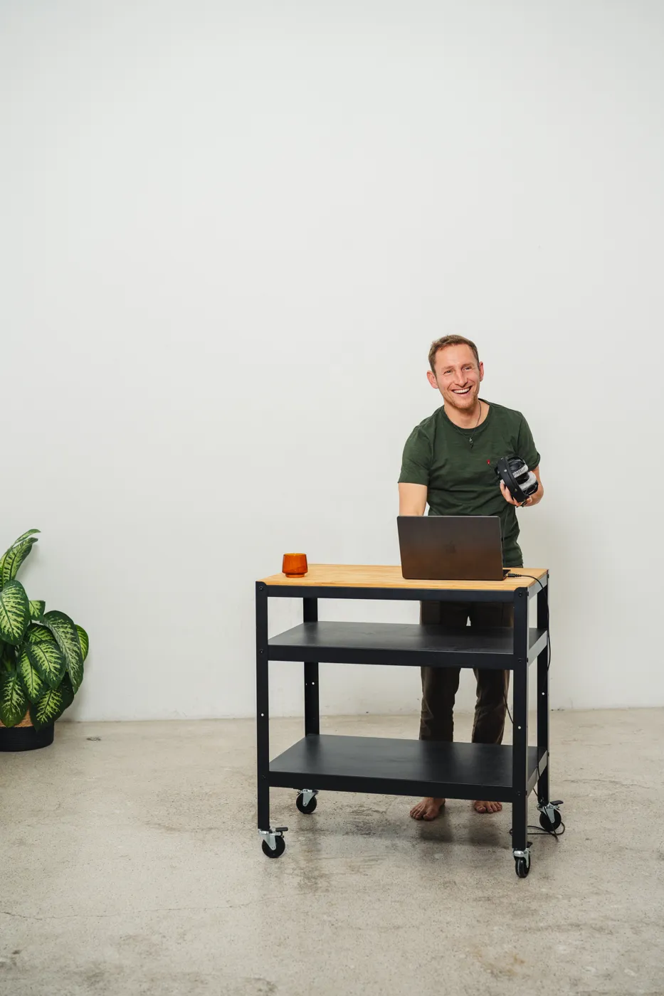 Jens staat lachend met zijn laptop aan een werkbank